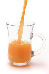 small transparent glass filled with orange juice