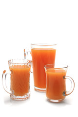 three small glasses with orange juice