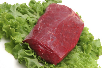 uncooked fresh beef meat on green salad