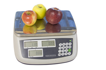 three apples on a digital produce scale isolated on white