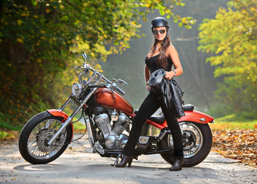 Biker girl standing next to a motorcycle