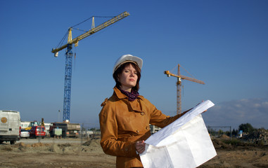 Young architect in front of construction site against blue sky