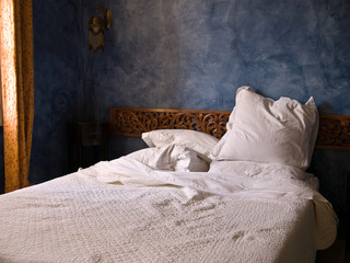 bedroom in the morning light with pillows threw askew.