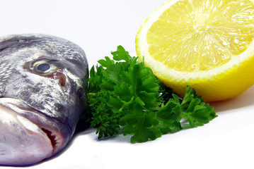 Detail view of a raw sea bream with parsley and lemon.