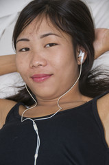 Attractive young Asian girl listening to music
