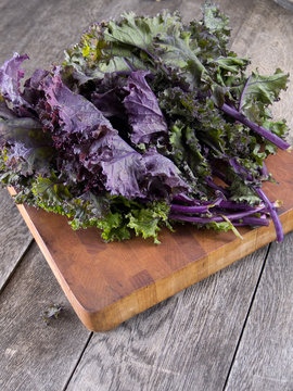 Red kale on a wooden cutting board