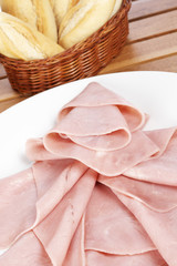 Ham on white dish and bread. Shallow depth of field
