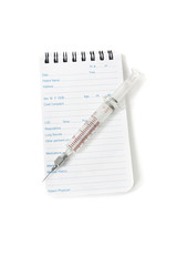 Medical notebook  and syringe needle on white background.