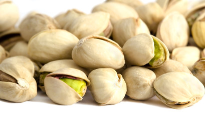 Roasted and salted pistachios on white background