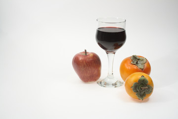 Isolated goblet of red wine with fruits on white background