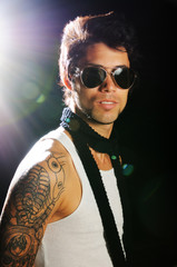 Portrait of young male fashion model with arm tattoo