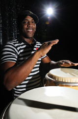 Portrait of young latino percusionist playing african drums