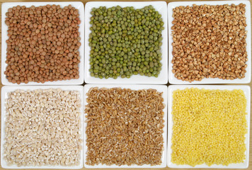 All sorts of beans and cereals sorted in ceramic containers.