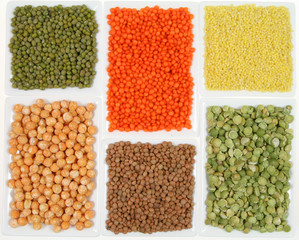 All sorts of beans and cereals sorted in  ceramic containers.