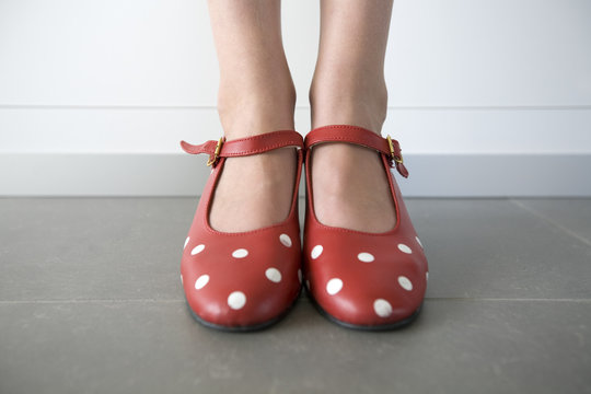 close-up of feet in red shoes with white dots