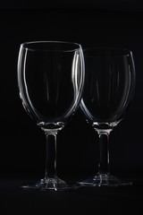 Two empty wine glasses isolated on black background.