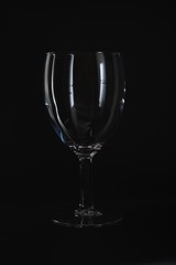 Empty wine glass isolated on black background.