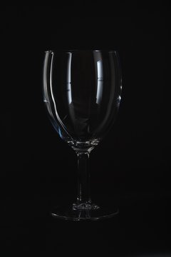 Empty wine glass isolated on black background.