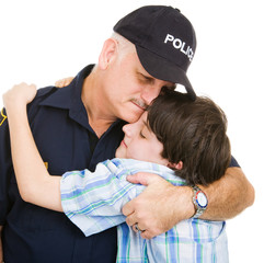 Policeman hugging an adolescent boy.    Isolated on white.