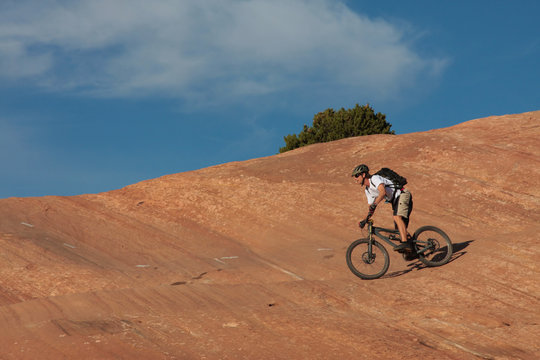 A skilled mountain biker on a red sandstone face.