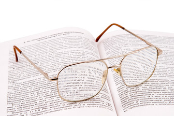 glasses laying on the open book