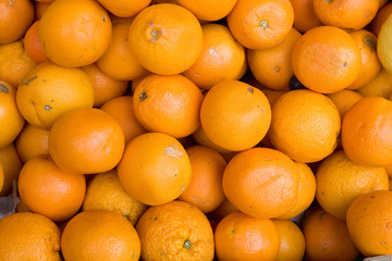 A background of fresh oranges in an outdoor market