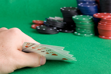 A poker hand with one pair - a poker player looking at his cards