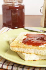 Toast with strawberry jam with shadow on background. Shallow DOF