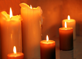 Close up of row of burning candles.