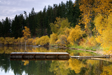 A dock on a calm lake in autumn.