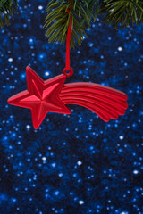 Christmas tree limb with red star glass ornament on stars