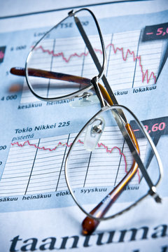 glasses on financial diagram. business concept