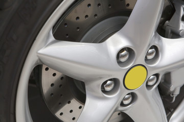 Silver rim with brake disk and black tyre