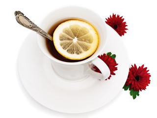 tea with lemon in white cup with red flower near it