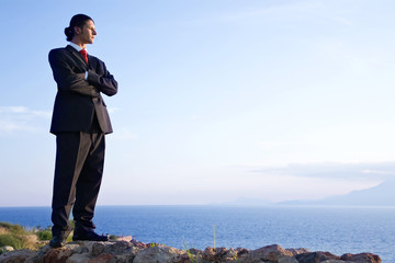 young businessman on the hill across the ocean