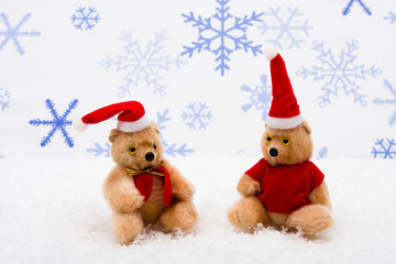 Stuffed bears wearing Santa hats on snowflake background
