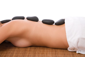Obraz na płótnie Canvas woman having hot stone massage at the spa center
