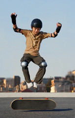 Boy jumping from skateboard wearing protective gear © goldenangel