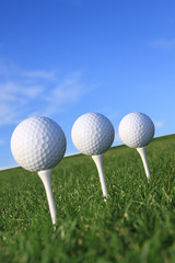 Drei Golfbälle auf Tee