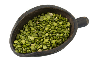 green split peas on a primitive, wooden scoop isolated