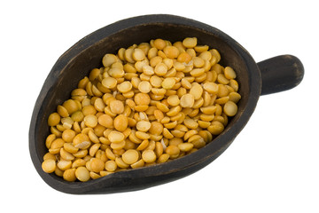 yellow split peas on a rustic, wooden scoop isolated
