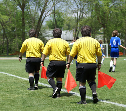 Triplet soccer side referee with red flag. Photo composition.
