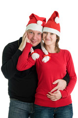 Young couple posing with funny Santa hats. Isolated over white