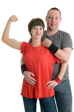 Young couple - girl is showing her biceps, man is behind her
