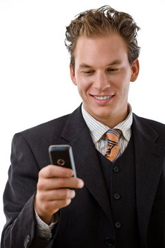 Businessman writing text message on mobile phone,
