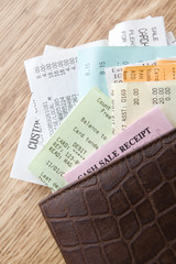 Brown Leather Wallet Filled With Receipts On Wooden Counter