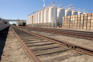 White tanks, rail cars, railroad tracks, food processing plant