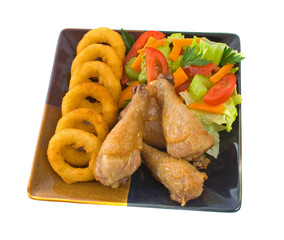 Roast chicken legs with onion rings and salad over white