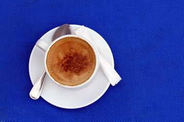 cup of capuccino on the blue background