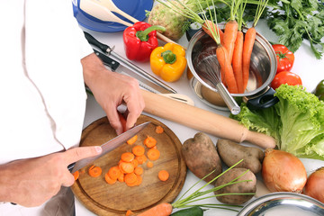 chef preparing lunch and cutting carrot with knife